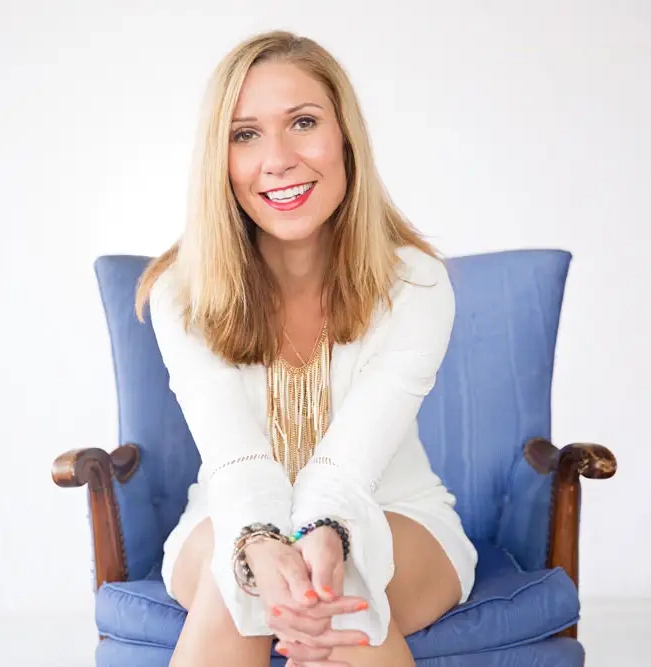 Woman smiling, seated in a comfortable chair